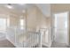 Upstairs hallway with neutral paint, white railings, and a view into other rooms of the home at 2081 The Oaks Blvd, Kissimmee, FL 34746