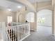 Upstairs hallway with carpet, white railing and views of the living room and Gathering room below at 2081 The Oaks Blvd, Kissimmee, FL 34746