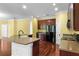 Modern kitchen featuring cherry wood cabinets, granite countertops, stainless steel appliances, and hardwood floors at 2081 The Oaks Blvd, Kissimmee, FL 34746