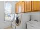 Laundry room with washer, dryer, utility sink, and window for natural light at 2081 The Oaks Blvd, Kissimmee, FL 34746