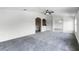 Open-concept living room with vaulted ceilings, neutral walls, gray carpet, and an archway at 2081 The Oaks Blvd, Kissimmee, FL 34746
