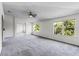 Large living room with plush carpeting, neutral walls, bright windows, and an archway to the dining room at 2081 The Oaks Blvd, Kissimmee, FL 34746