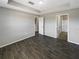 Neutral bedroom with a tray ceiling, wood-look tile flooring, and doors to the bathroom and closet at 2124 Betsy Ross Ln, St Cloud, FL 34769