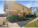 Tan two-story home with neat front shrubs and sidewalk leading to the front door at 2124 Betsy Ross Ln, St Cloud, FL 34769