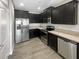 Modern kitchen with stainless steel appliances, granite countertops, and dark wood cabinets at 2124 Betsy Ross Ln, St Cloud, FL 34769