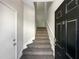 Carpeted stairway with white banister leading up to the second story, near the front door at 2124 Betsy Ross Ln, St Cloud, FL 34769
