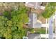 Aerial view of a neighborhood house surrounded by mature trees, well-maintained yards, and a quiet, tree-lined street at 2132 Majestic Woods Blvd, Apopka, FL 32712
