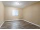 Cozy bedroom with neutral walls, modern laminate flooring, and a bright window offering natural light at 2132 Majestic Woods Blvd, Apopka, FL 32712
