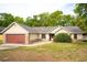 Charming single-story home with a red garage door, neat landscaping and a welcoming front entrance at 2132 Majestic Woods Blvd, Apopka, FL 32712
