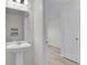 Powder room features a pedestal sink, decorative mirror, and neutral paint at 216 Miles Ct, Davenport, FL 33837