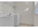 Functional laundry room with white washer and dryer, wire shelving, and natural light at 216 Miles Ct, Davenport, FL 33837