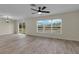 Bright living area featuring wood-look tile flooring, a ceiling fan, and a sliding glass door to the backyard at 216 Miles Ct, Davenport, FL 33837