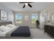 Stylish main bedroom with three windows, neutral carpet, and decorative artwork at 216 Miles Ct, Davenport, FL 33837