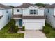 Charming two-story home featuring a two-car garage and a welcoming light-blue front door at 2237 Wood Stork Ln, St Cloud, FL 34771
