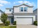Charming two-story home featuring a two-car garage and a welcoming light-blue front door at 2237 Wood Stork Ln, St Cloud, FL 34771