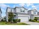 Charming two-story home featuring a two-car garage and a welcoming light-blue front door at 2237 Wood Stork Ln, St Cloud, FL 34771