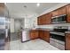 Well-equipped kitchen featuring stainless steel appliances and cherry wood cabinets at 2237 Wood Stork Ln, St Cloud, FL 34771