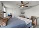 Bright main bedroom featuring a ceiling fan, tv, ensuite bathroom and rustic wood furniture at 2237 Wood Stork Ln, St Cloud, FL 34771