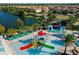 Aerial shot of splash-pad area with slides, loungers, shade, and a lake at 2412 Tanger Dr, Kissimmee, FL 34747