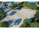 Aerial view of a well maintained beach volleyball court surrounded by palm trees at 2412 Tanger Dr, Kissimmee, FL 34747