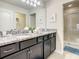 Well-lit bathroom with double vanity, granite countertop, modern cabinets, and walk-in glass shower at 2412 Tanger Dr, Kissimmee, FL 34747