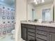 Bathroom boasts a double vanity with granite countertops, cabinets, and a shower at 2412 Tanger Dr, Kissimmee, FL 34747