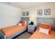 Charming bedroom with twin beds, framed art, a nightstand and a lamp at 2412 Tanger Dr, Kissimmee, FL 34747