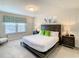 Bright bedroom features a large window, white bedding, dark furniture, and decorative accents at 2412 Tanger Dr, Kissimmee, FL 34747