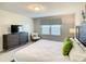 Relaxing bedroom with a flat-screen TV, comfortable chair, white bedding, and lots of natural light at 2412 Tanger Dr, Kissimmee, FL 34747