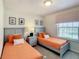 Charming bedroom with twin beds, framed art, a nightstand and a lamp at 2412 Tanger Dr, Kissimmee, FL 34747