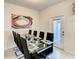 Contemporary dining area with a glass table, seating for eight, and convenient access to the outdoors at 2412 Tanger Dr, Kissimmee, FL 34747