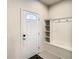 Bright entryway with white door, coat rack, and tile floor adding a modern touch and functionality to the space at 2412 Tanger Dr, Kissimmee, FL 34747