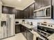 Well-equipped kitchen with dark wood cabinets, stainless steel appliances, and granite counters offering ample storage at 2412 Tanger Dr, Kissimmee, FL 34747