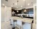 Modern kitchen features a large island with bar seating, granite countertops and stainless steel appliances at 2412 Tanger Dr, Kissimmee, FL 34747
