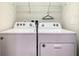 Convenient laundry room features a Whirlpool washer and dryer and wire rack shelving at 2412 Tanger Dr, Kissimmee, FL 34747