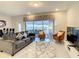 Modern living room featuring a comfortable gray sofa, stylish armchairs, and sliding glass doors to outdoor patio at 2412 Tanger Dr, Kissimmee, FL 34747
