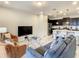 Open-concept living room showcasing contemporary furnishings, a large TV, and seamless flow to a modern kitchen at 2412 Tanger Dr, Kissimmee, FL 34747