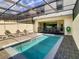 Relaxing screened-in pool area with lounge chairs, dining table, and well-maintained landscaping at 2412 Tanger Dr, Kissimmee, FL 34747