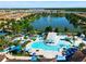 Aerial view of the community pool with ample lounge chairs, umbrellas, and a scenic lake nearby at 2412 Tanger Dr, Kissimmee, FL 34747
