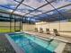 Inviting screened-in pool with lounge chairs offers a private outdoor oasis at 2412 Tanger Dr, Kissimmee, FL 34747