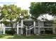 Two-story condo building featuring a staircase, balconies, neutral paint, and mature trees at 2593 Grassy Point Dr # 101, Lake Mary, FL 32746