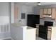 Galley kitchen featuring an open breakfast bar, black appliances, and ample counter space at 2593 Grassy Point Dr # 101, Lake Mary, FL 32746