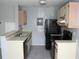 Neutral kitchen with stainless steel sink, ample counter space, and black appliances at 2593 Grassy Point Dr # 101, Lake Mary, FL 32746