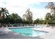 Community pool surrounded by lounge chairs and shaded areas with lush landscaping at 2593 Grassy Point Dr # 101, Lake Mary, FL 32746