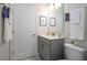 Modern bathroom features a gray vanity, white door, and decorative artwork, offering a clean, contemporary feel at 428 Ocean Course Ave, Davenport, FL 33896