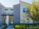 Contemporary townhome with a stone facade, green door, landscaped front yard, and modern architectural details at 428 Ocean Course Ave, Davenport, FL 33896