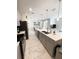A kitchen that includes an island, stainless steel appliances, and sleek tile flooring at 428 Ocean Course Ave, Davenport, FL 33896
