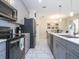 Modern kitchen features stainless steel appliances, gray cabinets, and tile floor at 428 Ocean Course Ave, Davenport, FL 33896