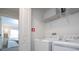 Clean laundry room with washer, dryer, storage shelf and door that opens to a bedroom at 428 Ocean Course Ave, Davenport, FL 33896