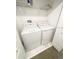 Efficient laundry area with a washer and dryer set, plus wire shelving for storage at 428 Ocean Course Ave, Davenport, FL 33896